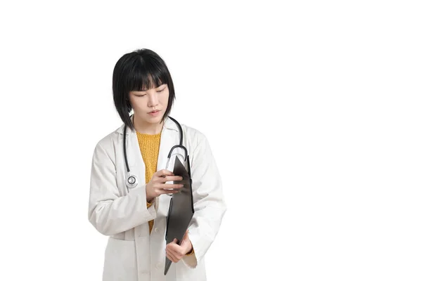 若いアジアの女性医師は彼女のフォルダ上の文書を探しています 白い背景に隔離されました — ストック写真