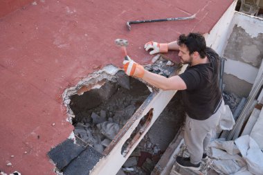 Genç adam tokmakla evin tavanını söküyor..