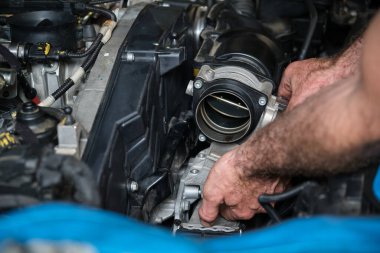 Araba tamircisi elleri, motor gazını değiştiriyor. Mekanik atölyesi.