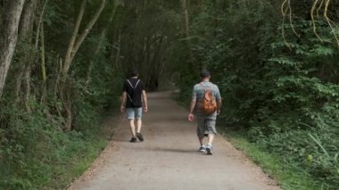 Two men walking along a path in Salburua park in Vitoria-Gasteiz, Basque Country in Spain.