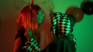 Two women dancing and laughing at a costume Halloween party.