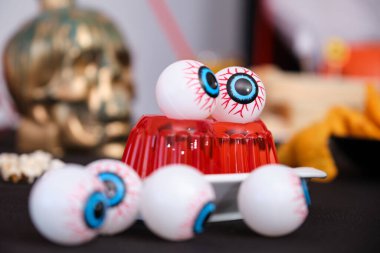 Halloween snacks table with eyeballs on red jelly. Sweets for Halloween party.