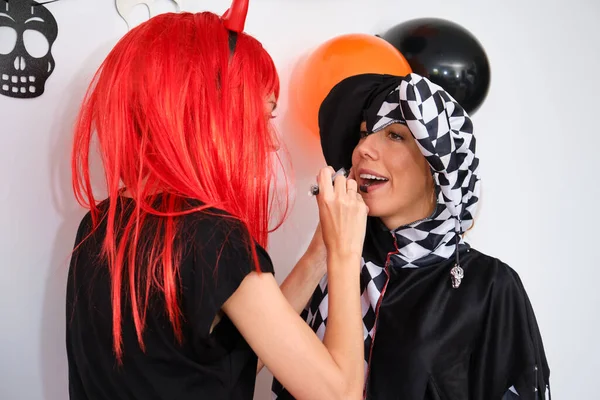 Woman Dressed Demon Applying Halloween Make Her Friend Dressed Harlequin — Stock Fotó