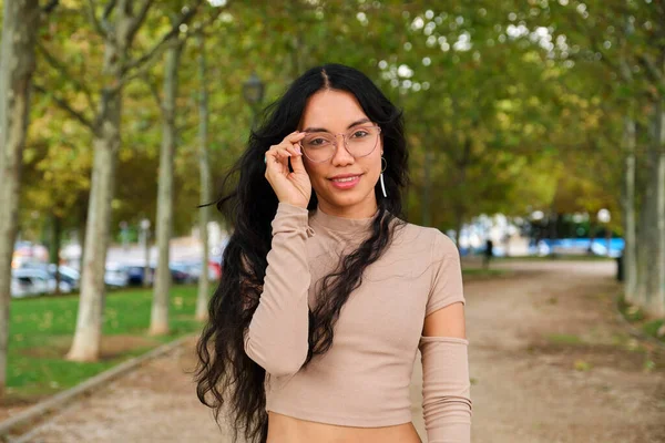 Joven Chica Latina Sosteniendo Sus Gafas Sonriendo Mirando Cámara Calle —  Fotos de Stock