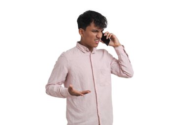 Kızgın ve omuz silken genç Perulu adam telefonda konuşuyor. Beyaz arkaplan üzerinde izole edilmiş.