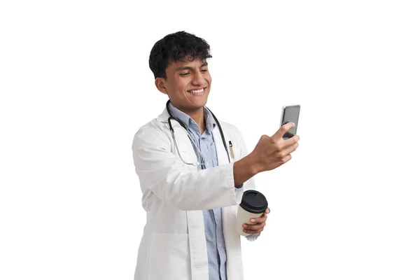 年轻的秘鲁男医生在电话里一边喝咖啡一边聊天 在白色背景下被隔离 — 图库照片