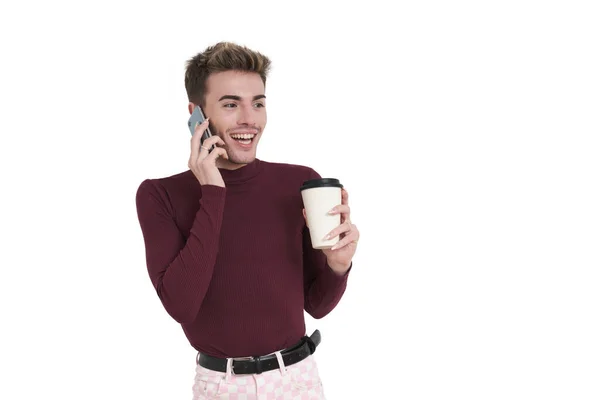 白人の背景の上に隔離されたコーヒーカップで電話で話して笑う若い白人男性 — ストック写真