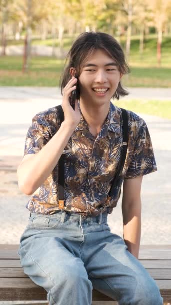 Νεαρός Ταϊβανέζος Άνδρας Χαμογελά Και Μιλάει Στο Smartphone Κάθεται Ένα — Αρχείο Βίντεο