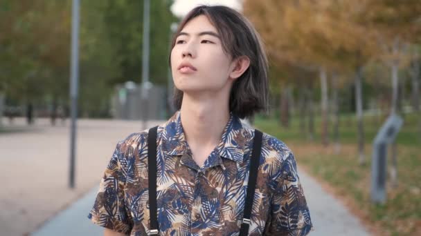 公園でカメラを見て笑っている若い台湾人の肖像画 — ストック動画