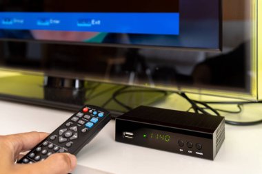 Uzaktan kumandalı ve televizyon izleyicili dijital şifre çözücü.