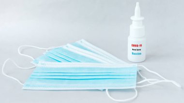 A bottle of nasal spry against covid-19 with surgical masks.