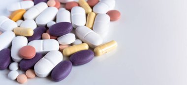 Pharmacy background on a white table. Pills and capsules.