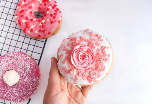 Симпатичный розовый пончик с розовым декором на белом фоне — стоковое фото
