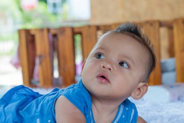 Yatağa uzanmış 6 aylık güzel bir bebek..