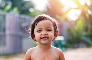 2-3 yaşlarında kısa siyah saçlı küçük bir kız mutlu bir şekilde gülümsüyordu. Sağlıklı çocuk kavramı.