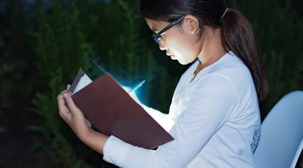 Close-up of the Bible in the hands of a beautiful girl ,The light from the scriptures hits the young woman\'s face, the concept of entering the church to pray.