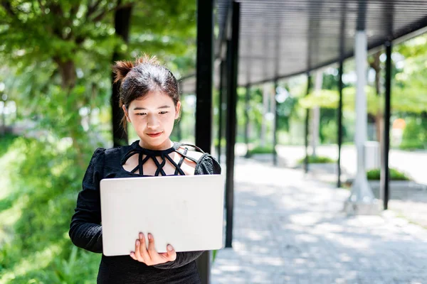 Beautiful businesswoman in black working on laptop . Comfortable work or remote work concept.