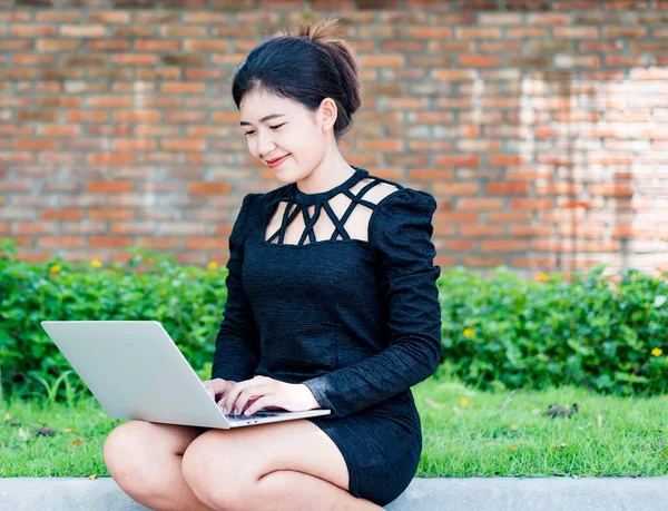 Beautiful businesswoman in black working on laptop . Comfortable work or remote work concept.