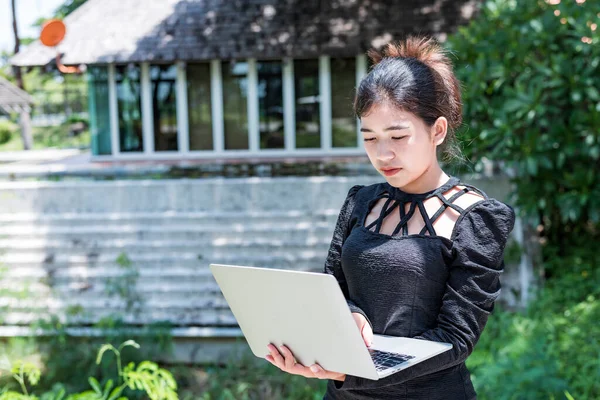 Beautiful businesswoman in black working on laptop . Comfortable work or remote work concept.