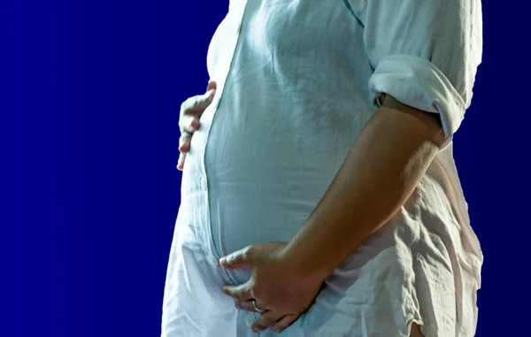 A pregnancy woman touch her stomach as she feel near labor pain.