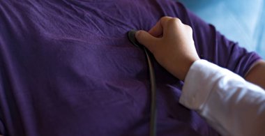 Tıbbi konsept. Doktor hastanın nabzını kontrol ediyor. Sağlık kontrolü. Doktor hastanın kalp atışlarını dinlemek için steteskop kullanıyor..