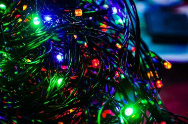 Karanlık bir arka planda bükülmüş Noel ağacı çelengi