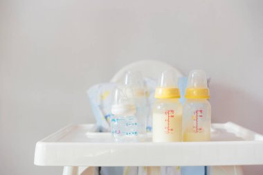 Bottle of milk for baby on high chair