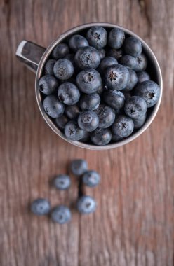 Fresh blueberries on cup wood background