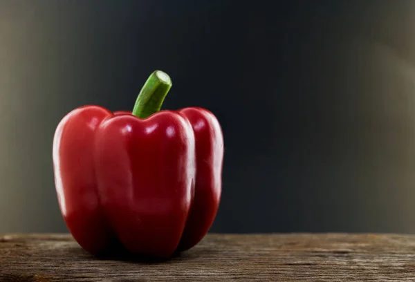 Sweet pepper, bell pepper red on old wood background, dark background