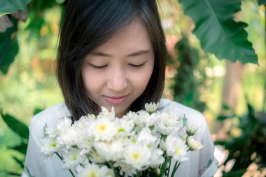 Beyaz çiçekleri tutan kadın