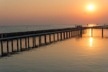 Denizde gün batımı Denizde ahşap köprü