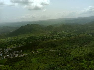 peak view from sajjangarh palace  green aravali hils and sky and udaipur cit