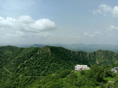 peak view from sajjangarh palace  green aravali hils and sky in udaipur