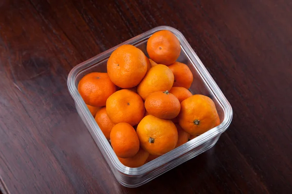 Fresh Clementines fruit with glass bowl on wood table — Stock Photo, Image