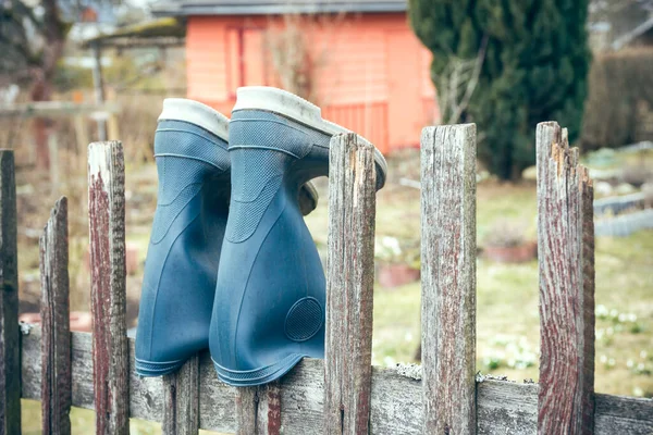 Niebieskie Gumowe Buty Zwisające Drewnianego Ogrodzenia — Zdjęcie stockowe