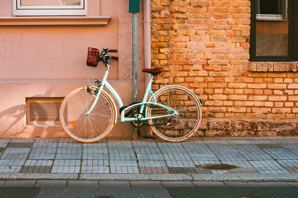 a ladies bike in a city in front of a brick wall house