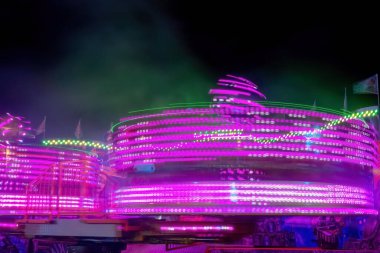 Geceleri neon renklerle dönen bir fuar.