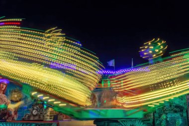 Geceleri neon renklerle dönen bir fuar.