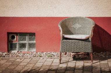Gün ışığında bir ev duvarının önünde bir sandalye