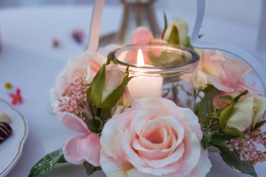seçici odak içinde mum ve yapay gül ile masa dekorasyonu