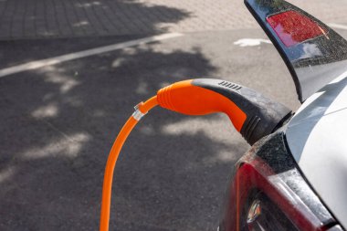Şarj istasyonunda şarj edilen beyaz bir elektrikli araba.