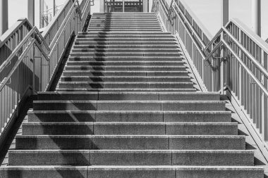 Bir şehirde siyah beyaz parmaklıklı bir merdiven.