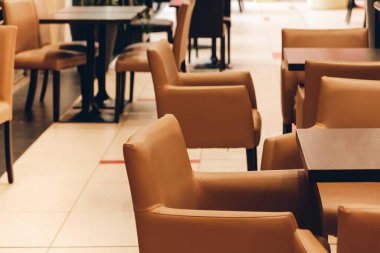 Bir sokak kafesinin döşenmiş kahverengi sandalyeleri.