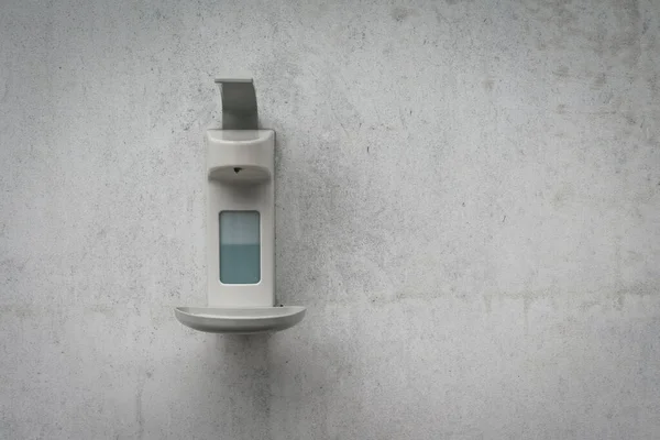 a disinfection tank on a gray house wall