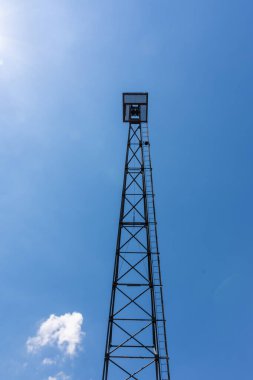 Aşağıdan mavi gökyüzüne bakan eski bir endüstriyel vinç.