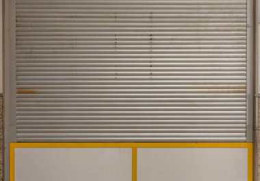 a closed shop window with roller shutter in a city