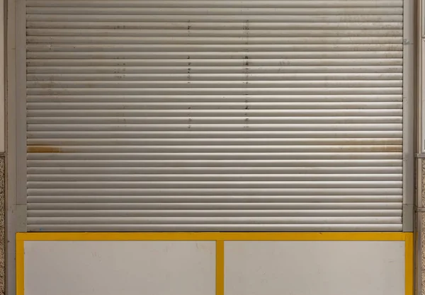 a closed shop window with roller shutter in a city