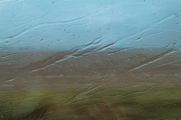 rain drops at the window with nature in the background