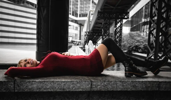 Kırmızı Elbiseli Genç Bir Kadın Taştan Bir Duvarda Yatıyor — Stok fotoğraf