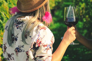 Üzüm bağında kırmızı şarap kadehlerini tokuştururken ellerinizi kapatın.